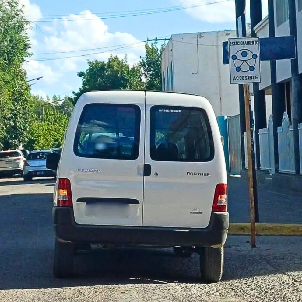 Un vehículo utilitario estacionado donde la señalizacón marca que esta destinado para personas con discapacidad