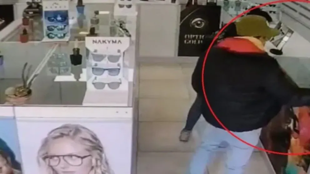 El momento en que el joven toma un par de lentes en una óptica del centro de Roca, quedo registrado en las cámaras de seguridad. Foto (Gentileza).