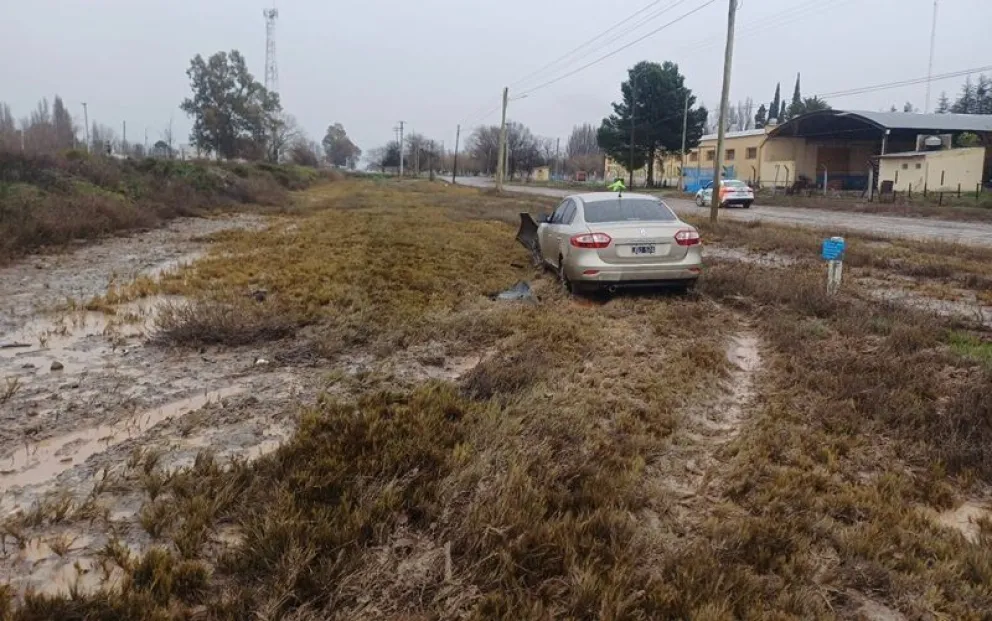 El auto quedó a pocos metros de una calle rural de Godoy después de despistarse por el agua en la 22 y volar sobre las vías del ferrocarril. Fotos: gentileza
